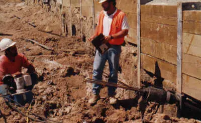 Crew installing soil nails on a cut slope
