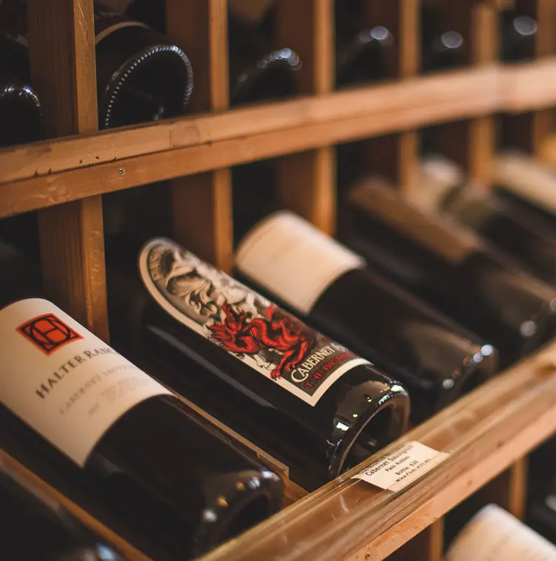 Wine bottles on wooden cellar racks
