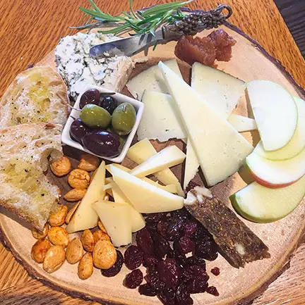 Cheese board with fruit, nuts and olives